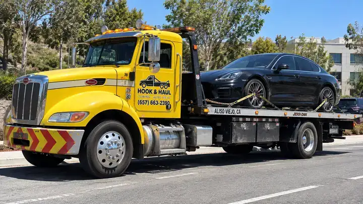 Hook & Haul flatbed tow truck in Aliso Viejo hauling a black sedan